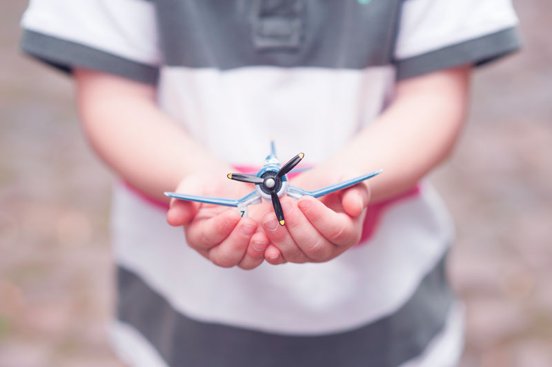 Potenziale erkennen – Jedes Kind hat individuelle Stärken Kind hält ein Spielzeugflugzeug – Symbol für Potenzialentfaltung und individuelle Entwicklung.